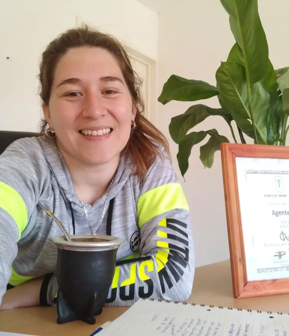 Meli en su espacio de trabajo con diploma de turismo